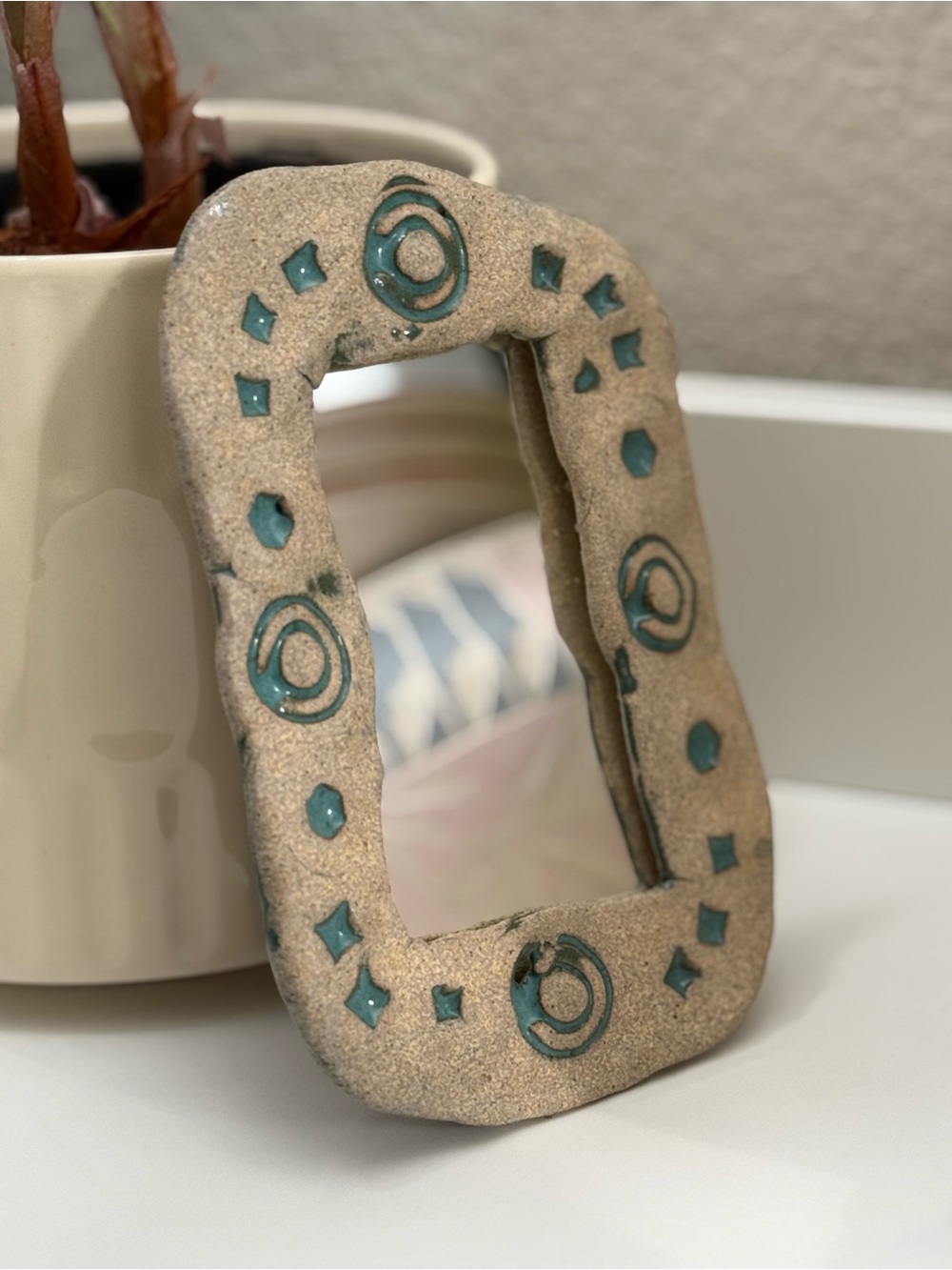 Textured Sandstone Mirror with Teal Geometric Accents